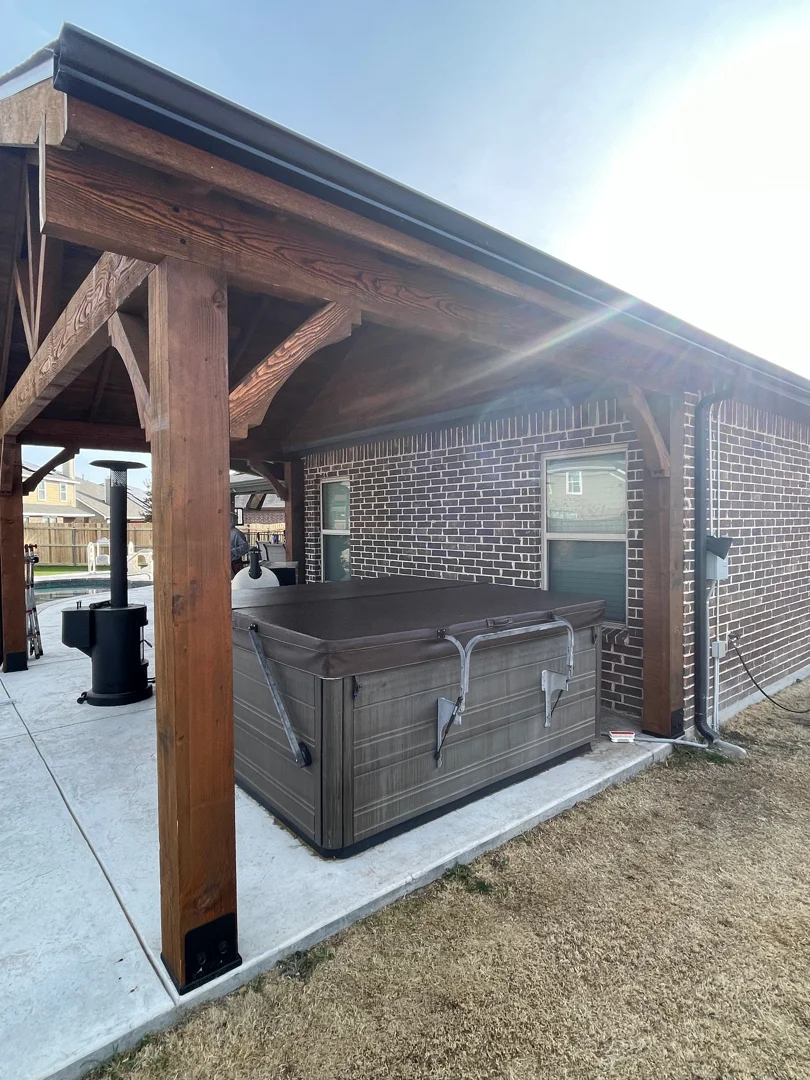 Bronze seamless gutters on a brick Dallas home with patio cover and hot tub area