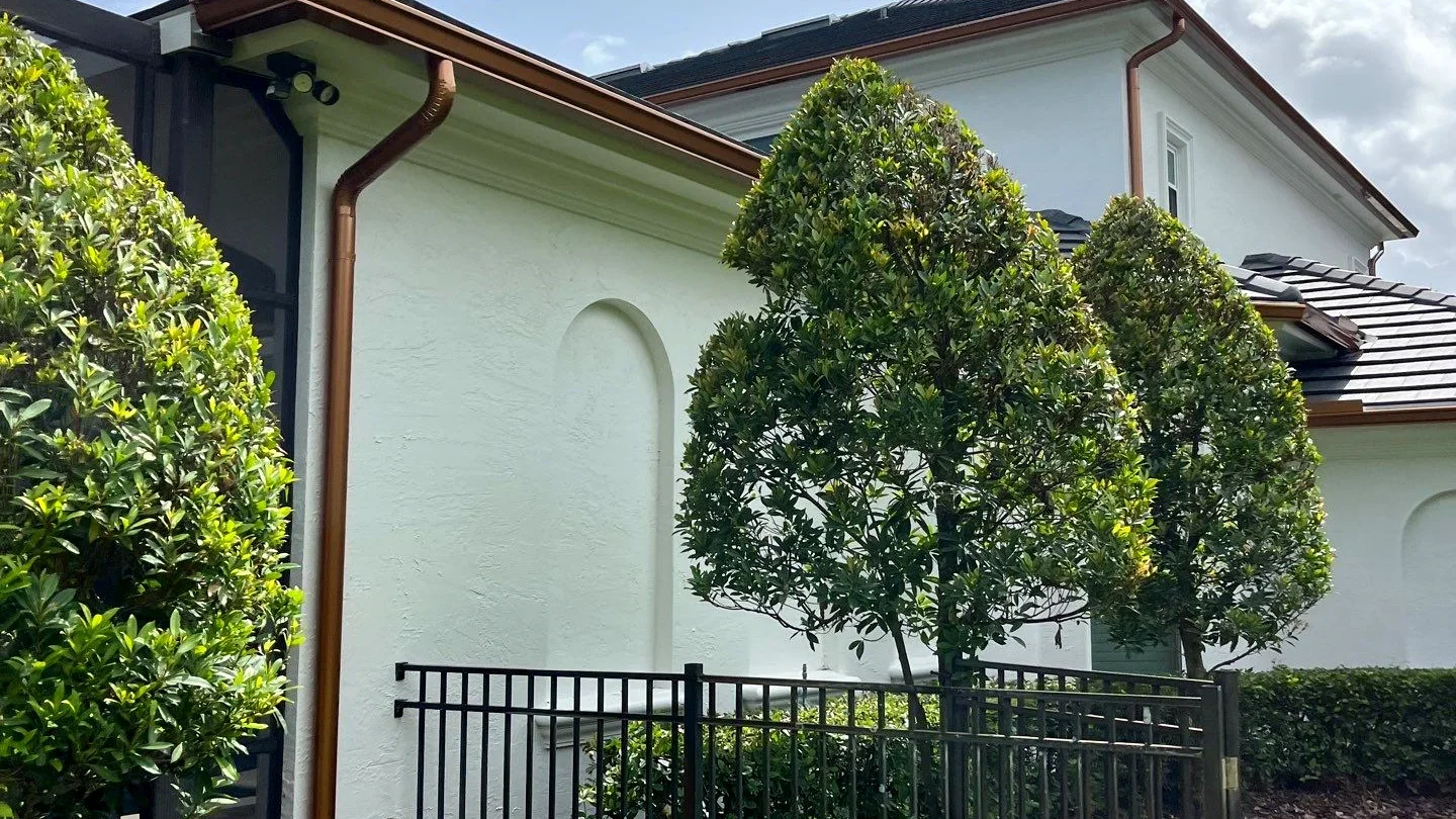 Downspout directing runoff away from a driveway and foundation