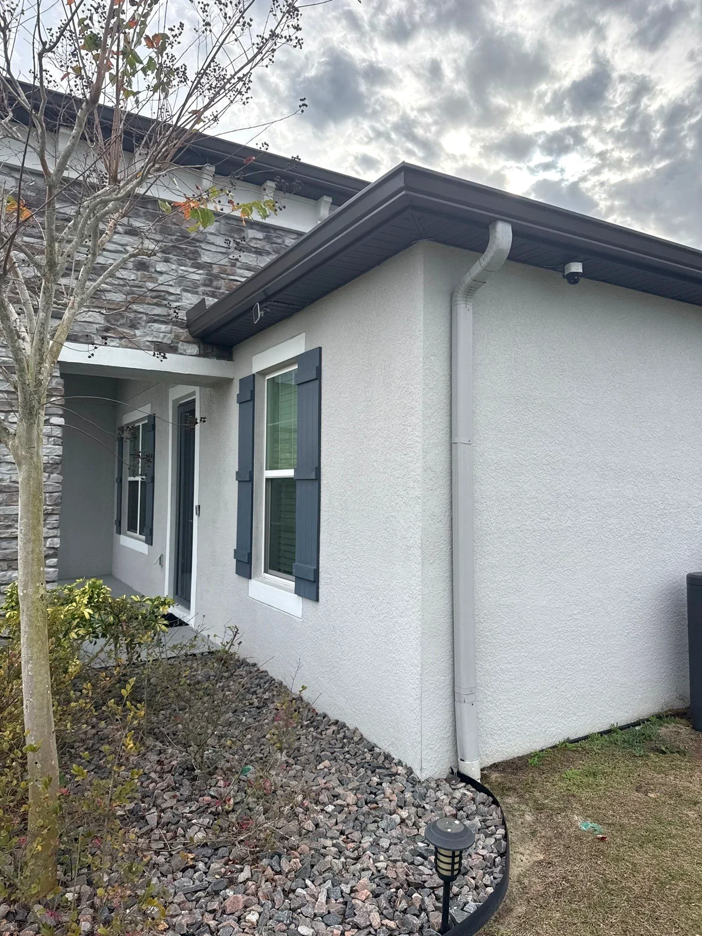 Seamless gutter installation on a Fort Worth home front elevation